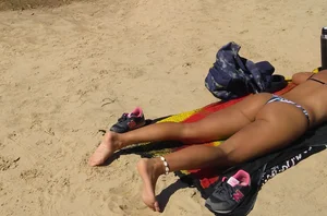 Sexy girl getting some sun laying on the beach in thong bikini
