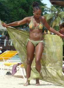 Sexy black babe in various bikinis on the beach while on vacation