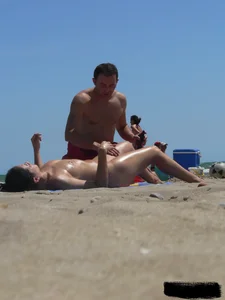 Purple thong topless lady on the beach gets oiled up by her husband