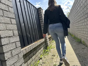 Sexy girl in tight blue jeans walking down a suburban street creepshots