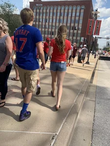 Bunch of girls in various outfits at a Cardinals baseball game