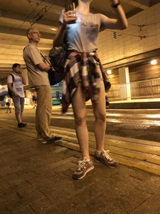 Cute Teen in Shorts on the Tram Stop