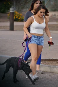 Sexy dog walker in shorts and tank top with friend in blue jeans