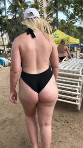 Chubby blonde in a swumsuit walking on the beach
