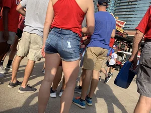 Bunch of girls in various outfits at a Cardinals baseball game