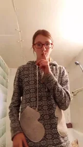 Cute non-candid bespectacled girl in bathroom showing her bra and tummy