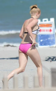 Skinny blonde girl on the beach in her pink and white bikini