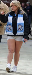 Curvy blonde girl in soccer / football kit & shorts poses for photos