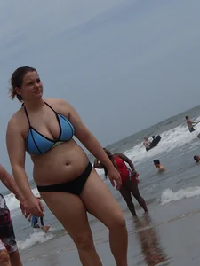 Big boobed girl on the beach in blue and black bikini