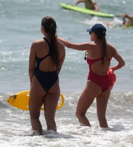 Two sexy lifeguards in red and blue swimsuits
