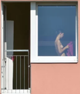 Peeping Tom pics of a topless girl in her house with nice tits