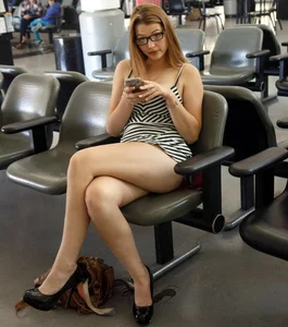Hot candid milf wearing glasses and a short dress sitting at the airport with crossed legs creepshot