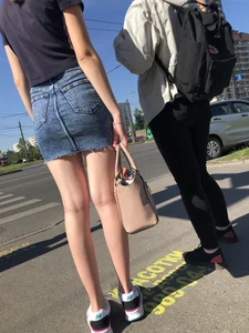 Cute Girl in a Short Denim Skirt Walking on a Street And Waiting on a Crosswalk Gallery
