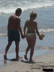 Sexy blonde on the beach in a yellow thong bikini