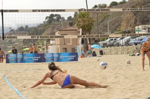 Sexy beach volleyball girl in sport bra top with pokies and blue bikini bottom