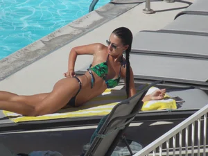 Hot milf sunbathing in a thong by pool and swimming