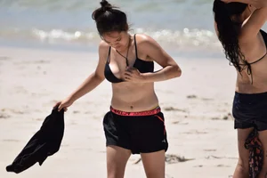 Beach girl can't keep her tits in her bikini