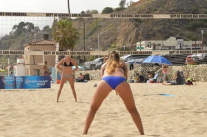Sexy beach volleyball girl in sport bra top with pokies and blue bikini bottom