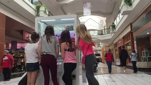 Little blonde teen in grey leggings at the mall with her friends