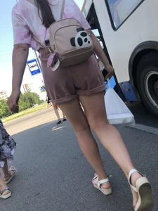 Young Girl in Sandals and Shorts in a Public Bus