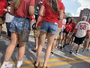 Bunch of girls in various outfits at a Cardinals baseball game
