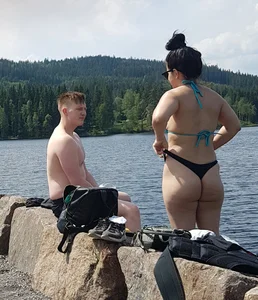 Thick brunette at the lake in a black thong bikini