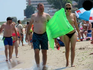 Topless blonde babe on the beach with a big booty in a black thong