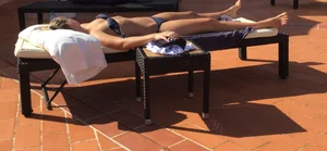 Blonde laying out in a blue bikini with a sexy body