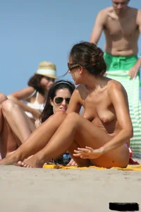 2 topless girls at the beach in thongs