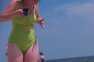 Redhead laying on the beach in green swimsuit