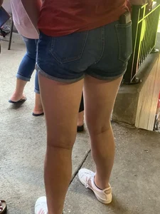 Bunch of girls in various outfits at a Cardinals baseball game