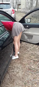 Girl in a skirt bending over to her car, nice legs