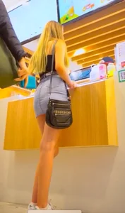 Hot blonde girl flashing her panties under the short denim skirt at the mall
