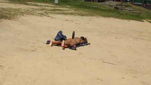 Sexy girl getting some sun laying on the beach in thong bikini