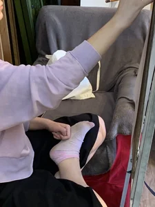 Teen Artist Student's Crossed Legs And Feet in Socks Closeup Photo