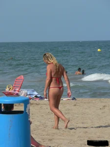 Sexy mom and daughter in red thongs at the beach