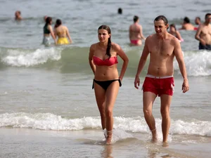 Skinny small boobed girl in a bikini on the beach with her friend