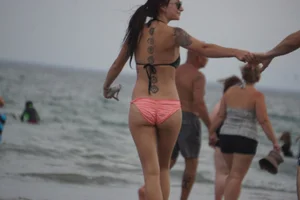 Peach bikini tattood babe on the beach with a nice ass and some camel toe