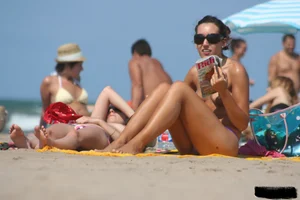 2 topless girls at the beach in thongs
