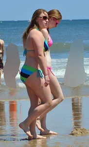 Two beach friends in bikinis one with back dimples and the other thick