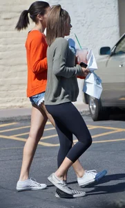 Brunette in tiny shorts walking with her sexy friend in leggings