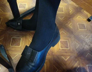 Young Girl's Feet in Black Pantyhose - Crossed Legs Under Desk Closeup Photo
