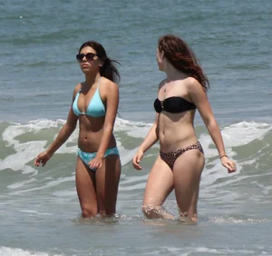 Brunette and redhead on the beach in bikinis looking sexy