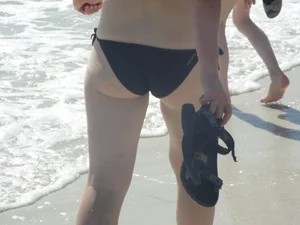 Lady on the beach in black bikini with nice ass