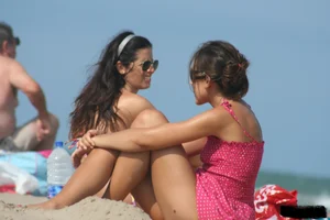 2 topless girls at the beach in thongs