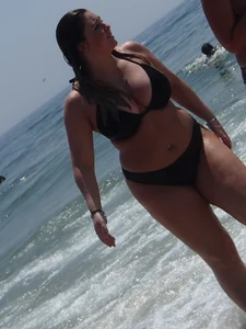 Thick beach babe with big tits in a thong bikini