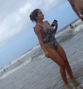 Cute lady at the beach with a nice body in a floral swimsuit