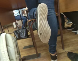 Sole of a Skinny College Girl’s Sneaker in Tight Blue Jeans Photo