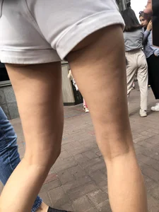 Hot Candid Girl in a Top, Shorts and Sneakers Skinny Legs Closeup Creepshots Gallery on the City Street