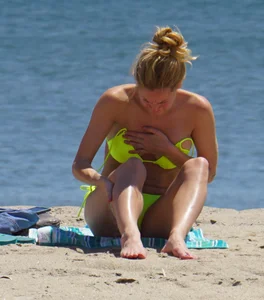 Sexy ass blonde milf on the beach in a thong with cameltoe and bending over